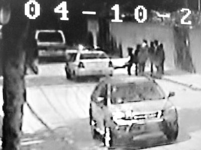 视频截图中,姑娘正用脚踢警车