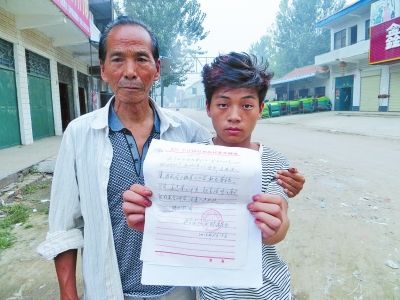 董本杰和他的养父展示村里开具的收养证明 